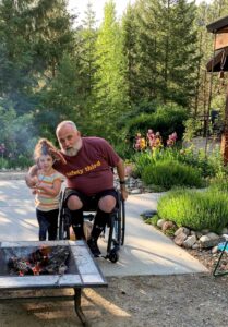 Matt Thomas and his daughter next to a campfire in the woods